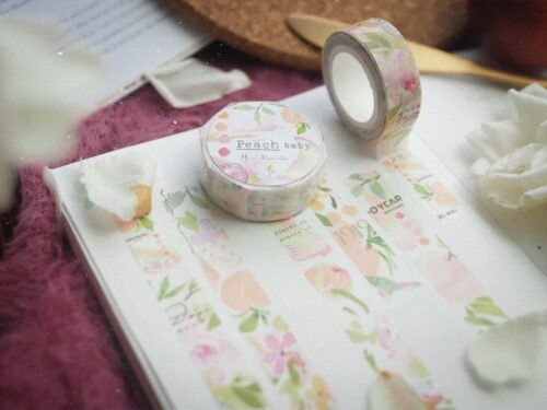 Peach Baby Washi Tape on notebook with floral design.
