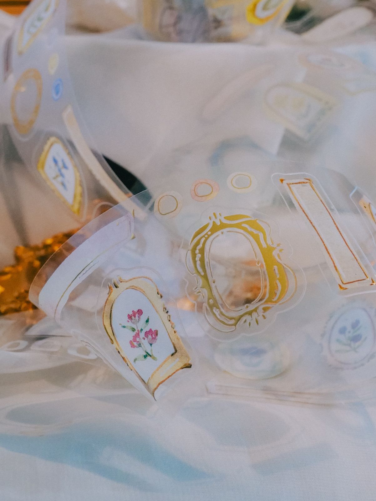 Glossy kiss-cut PET tape with matte gold foil frames and floral designs.