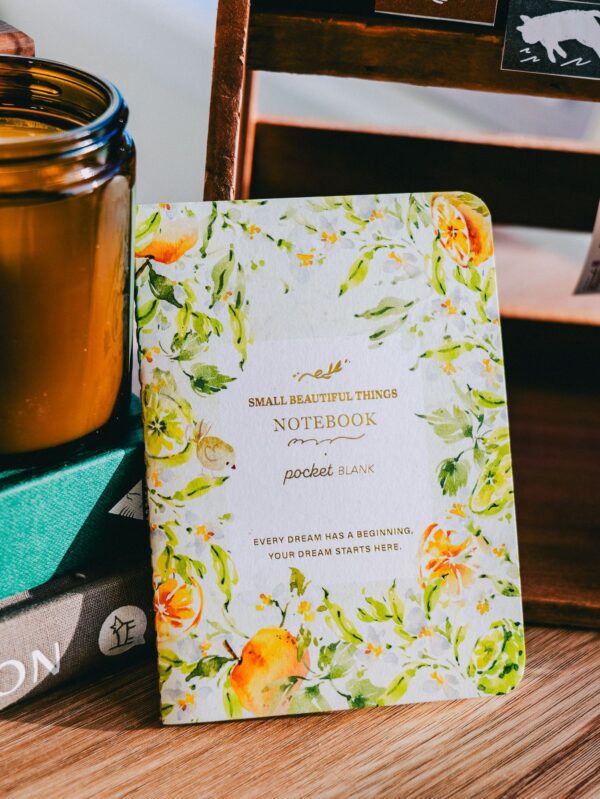 Gold foil passport notebook with orange blossom design, ideal for travel.