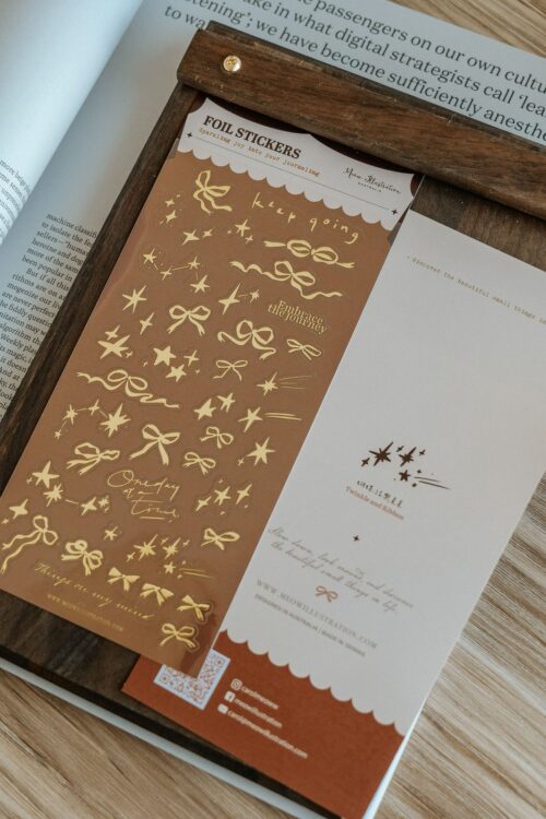 Gold foil transparent sticker sheet with bows and stars design.