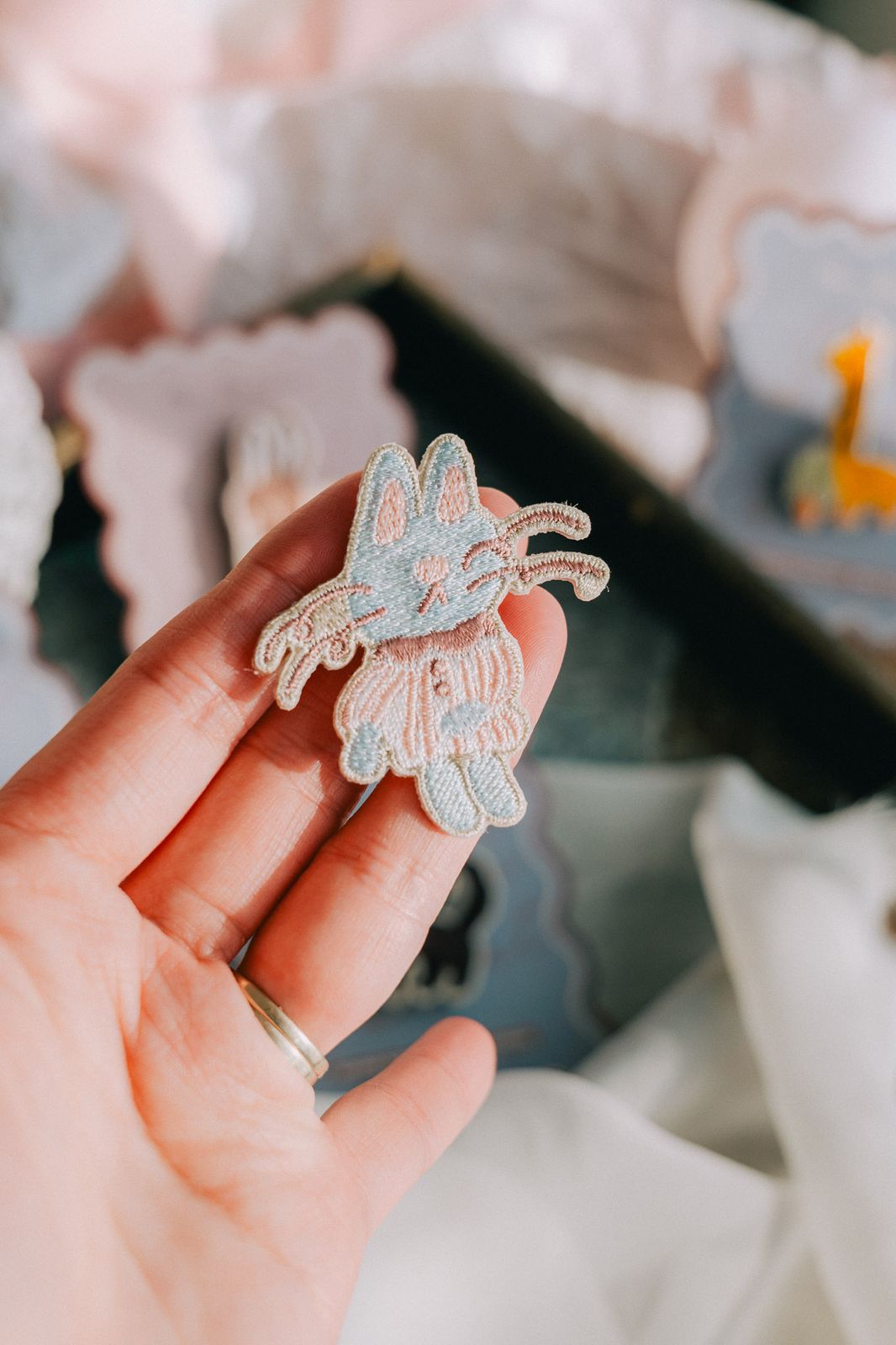 Pink Magician Cat embroidered pin held in hand, whimsical design.