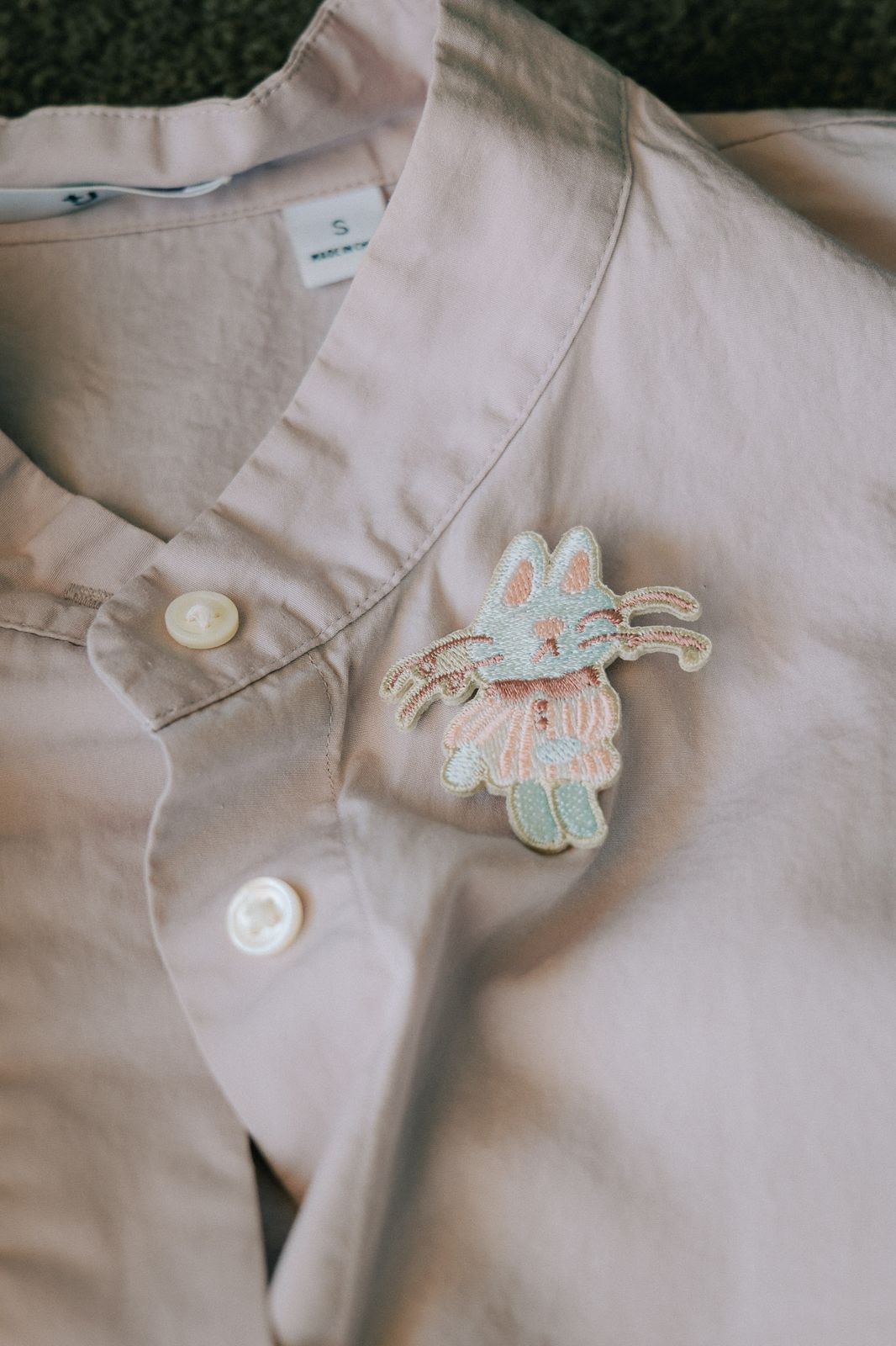 Pink Magician Cat embroidered pin on a shirt, 4.6 x 5 cm, silver pin.